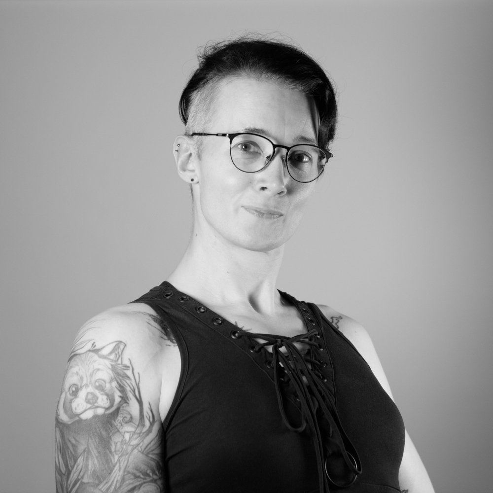 Black and white headhot of a woman with short black hair and a grey sidecut